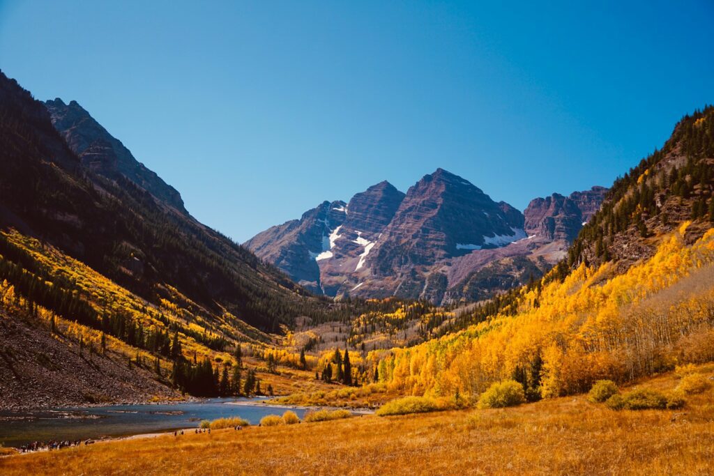 green trees and brown mountains under blue sky during daytime in aspen as romantic idea for couples